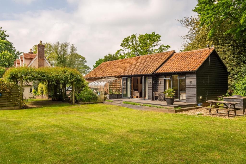 a barn conversion with a garden and a house at The Lodge, Wherstead 