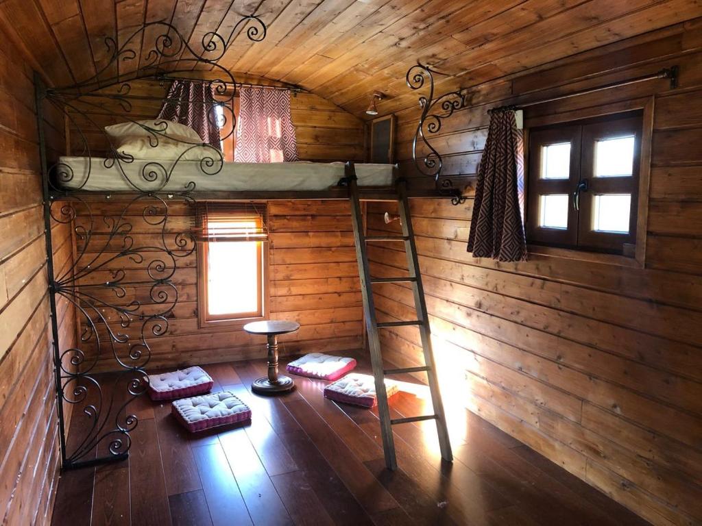 a room with a bunk bed in a log cabin at Les roulottes de cirque Les Settons in Moux-en-Morvan