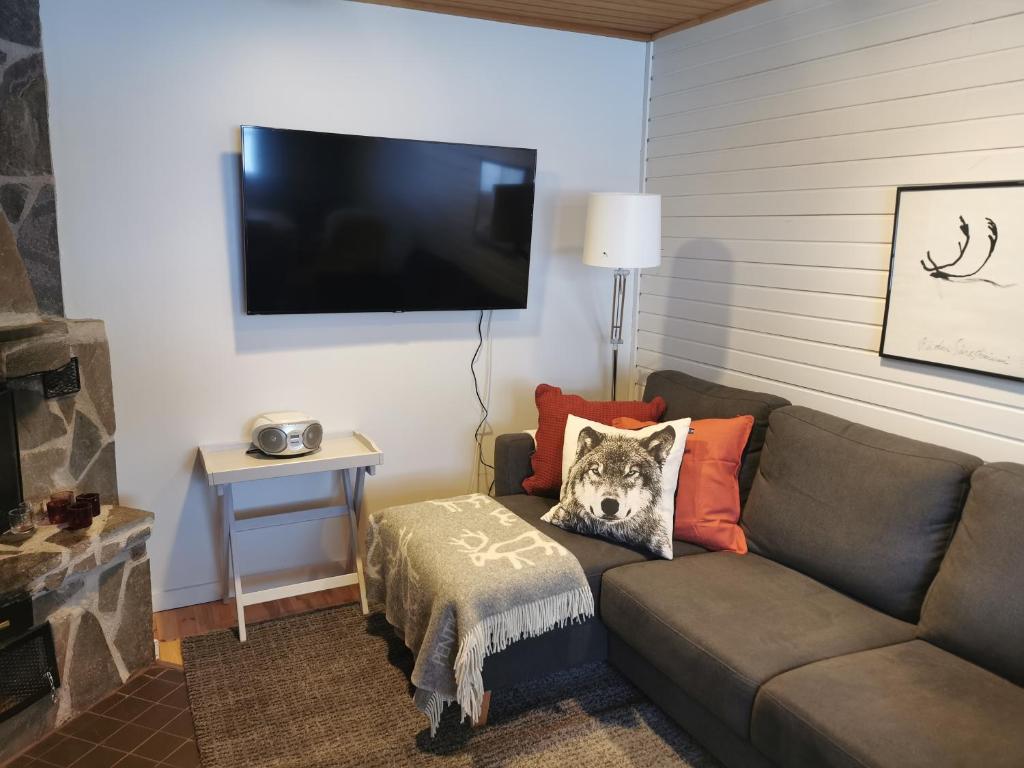 a living room with a couch with a dog pillow on it at Winter Nest - A cozy accommodation in the heart of Saariselkä in Saariselka