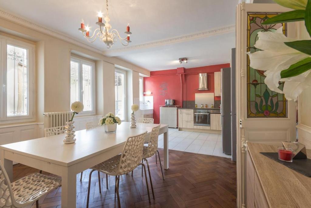 cocina y comedor con mesa y sillas en Les Hortensias, en Nolay