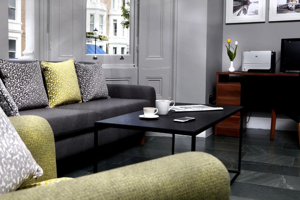 a living room filled with furniture and a coffee table at Lord Jim Hotel London Kensington in London