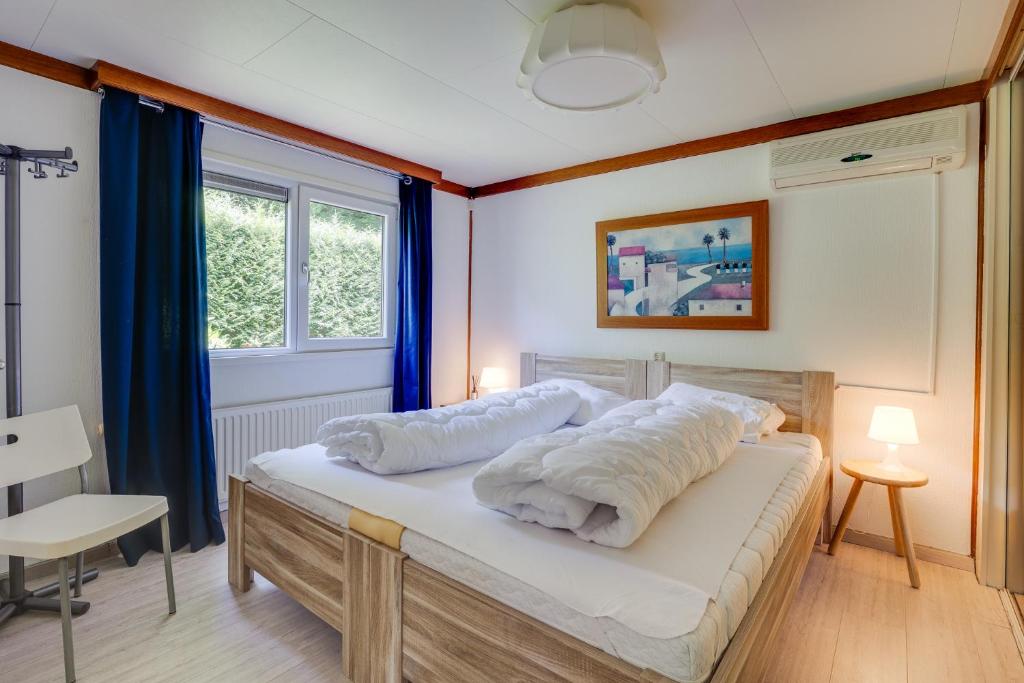 een slaapkamer met een bed met witte kussens erop bij Bungalowpark Het Verscholen Dorp in Harderwijk