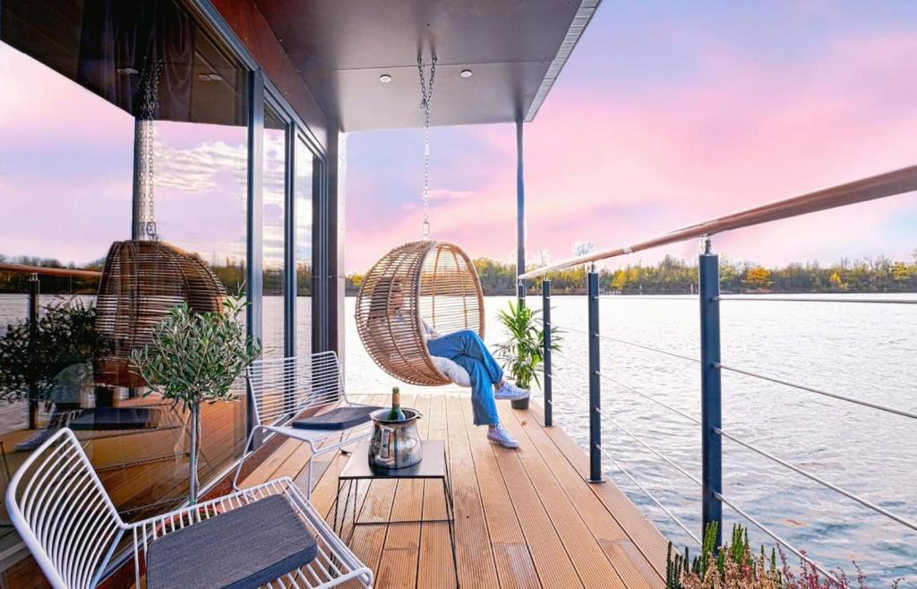 eine Terrasse auf einem Boot mit Stühlen und Wasser in der Unterkunft Escale Royale Port Ilon in Saint-Martin-la-Garenne