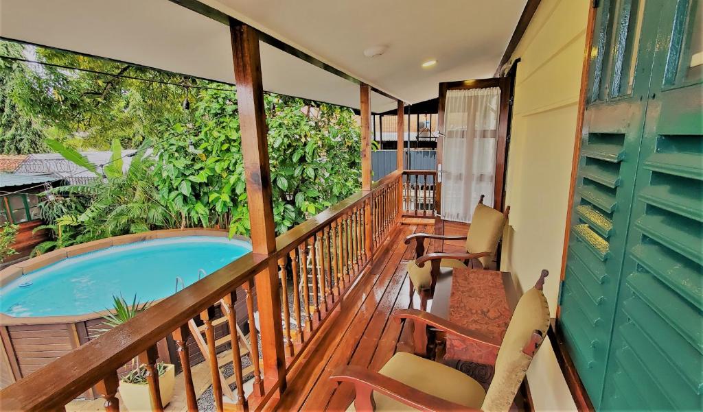 uma varanda com uma banheira de hidromassagem e cadeiras em Prins Hendrik Suites em Paramaribo