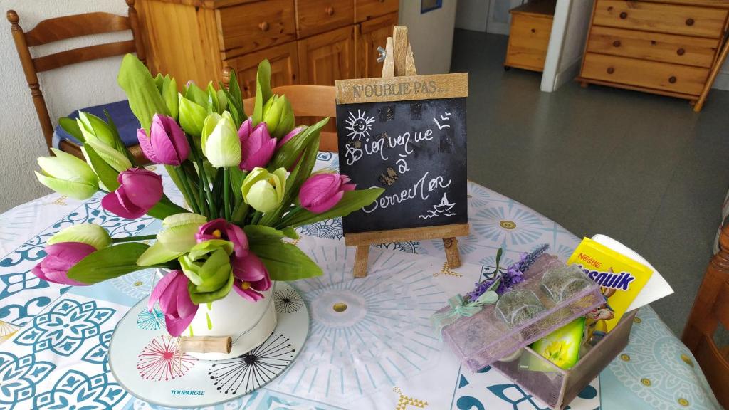 une table avec un vase de fleurs et un tableau de craie dans l'établissement Terremer, au Tréport