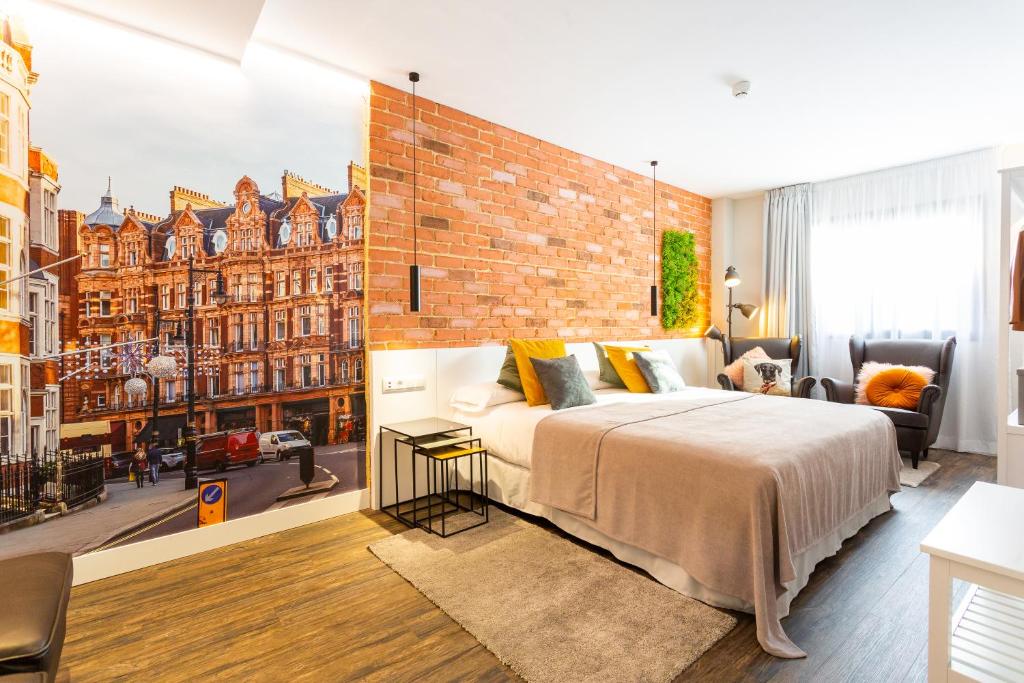 a bedroom with a large bed and a brick wall at Fly Rooms Madrid Airport in Madrid