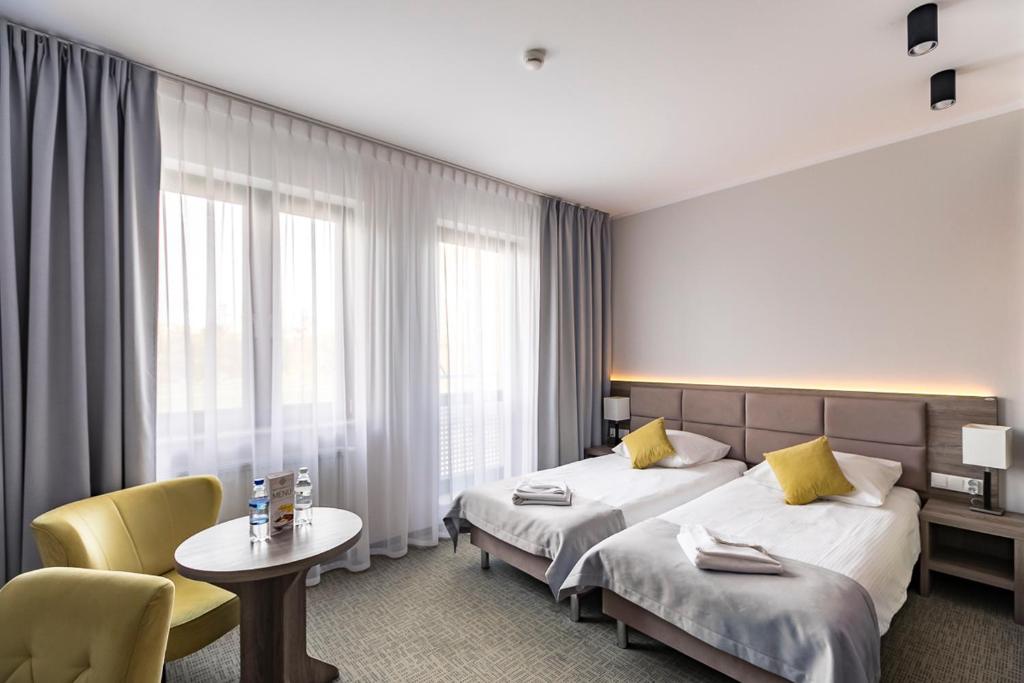 pokój hotelowy z 2 łóżkami i stołem w obiekcie Meet Poznań Hotel w Poznaniu