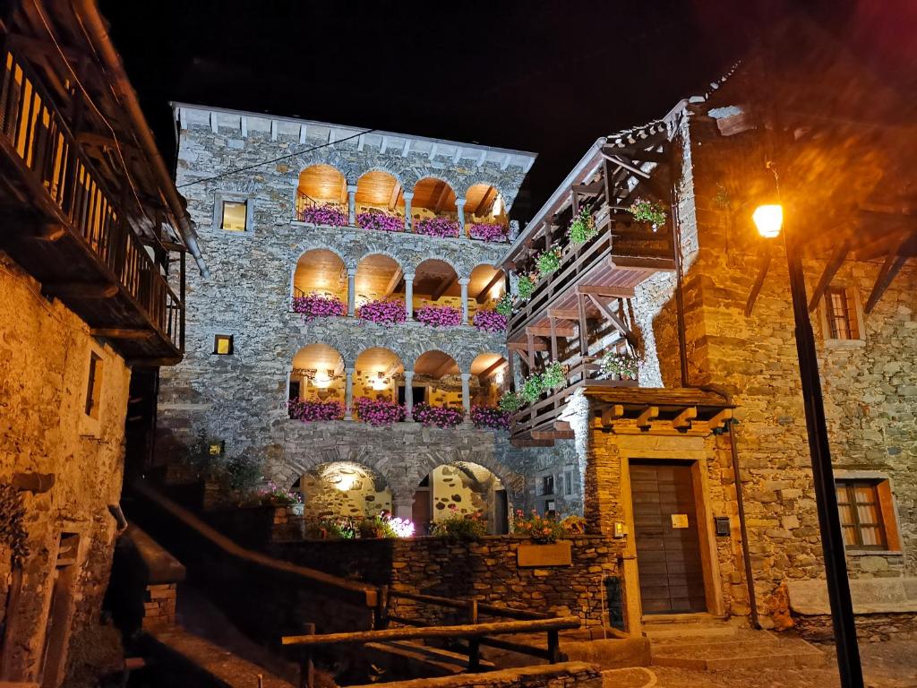 stary kamienny budynek z balkonami i światłami w obiekcie Dimora Storica Casa Vanni w mieście Villadossola