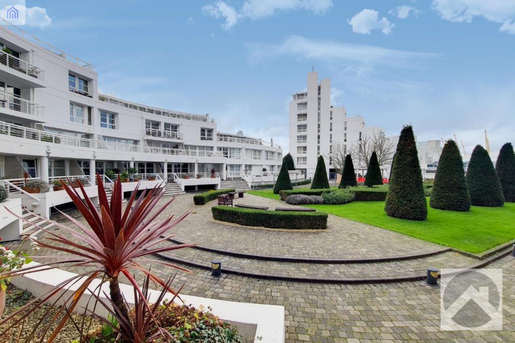 a courtyard of a building with trees and bushes at Canary Wharf Apartments By Austin David in London