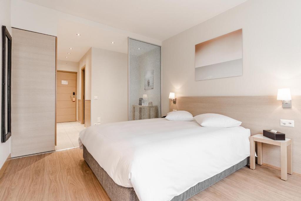 Postel nebo postele na pokoji v ubytování Starling Hôtel Résidence Genève
