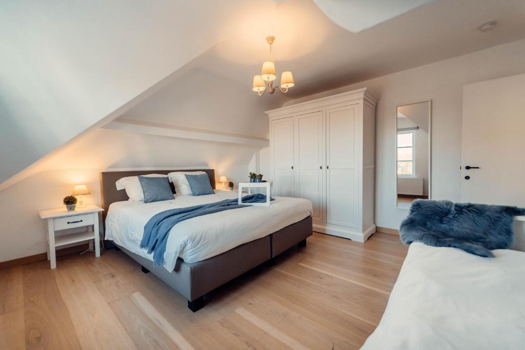 ein Schlafzimmer mit einem großen Bett mit blauen Kissen in der Unterkunft Villa Promenade - luxuriously apartment for 8 people in Nieuwpoort
