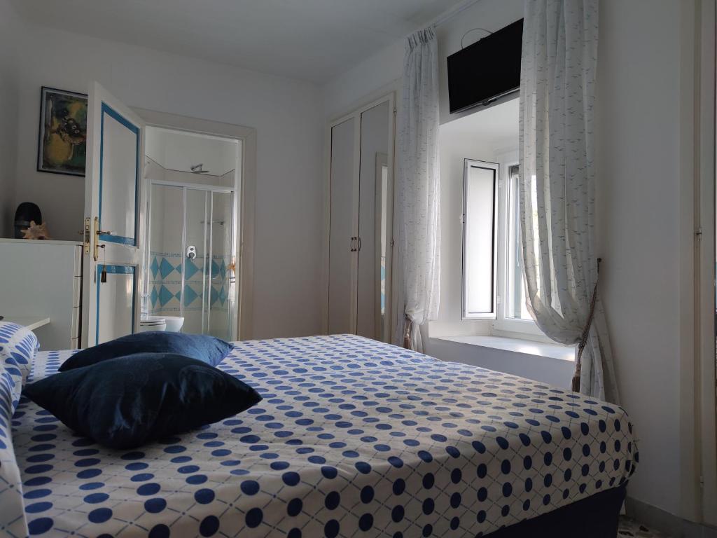 um quarto com uma cama com um edredão azul e branco em Maison Lucienne em Minori