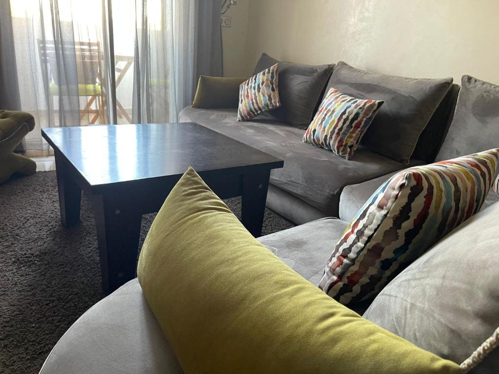 a living room with a couch and a coffee table at Lovely one-bed flat with fiber optic and shared swimming pool in Agadir