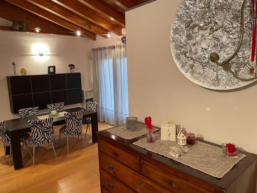 uma sala de jantar com uma mesa e um espelho na parede em Sweet Home em Concordia Sagittaria