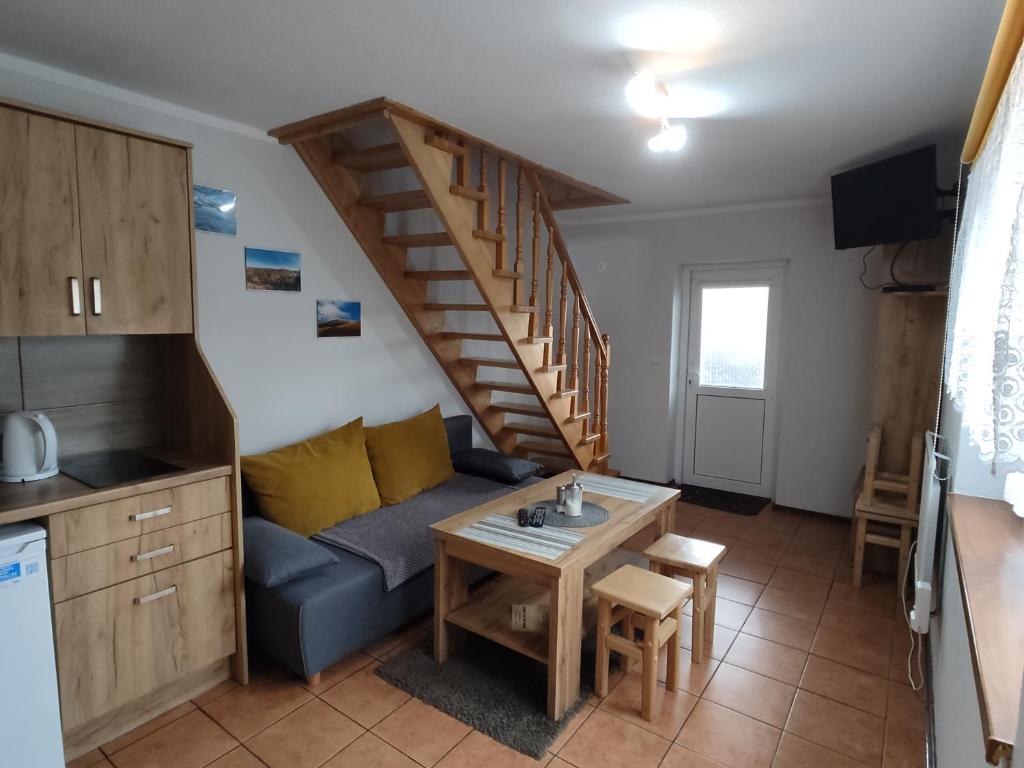 a living room with a blue couch and a staircase at Domki u Strażaka obiekt Całoroczny in Solina
