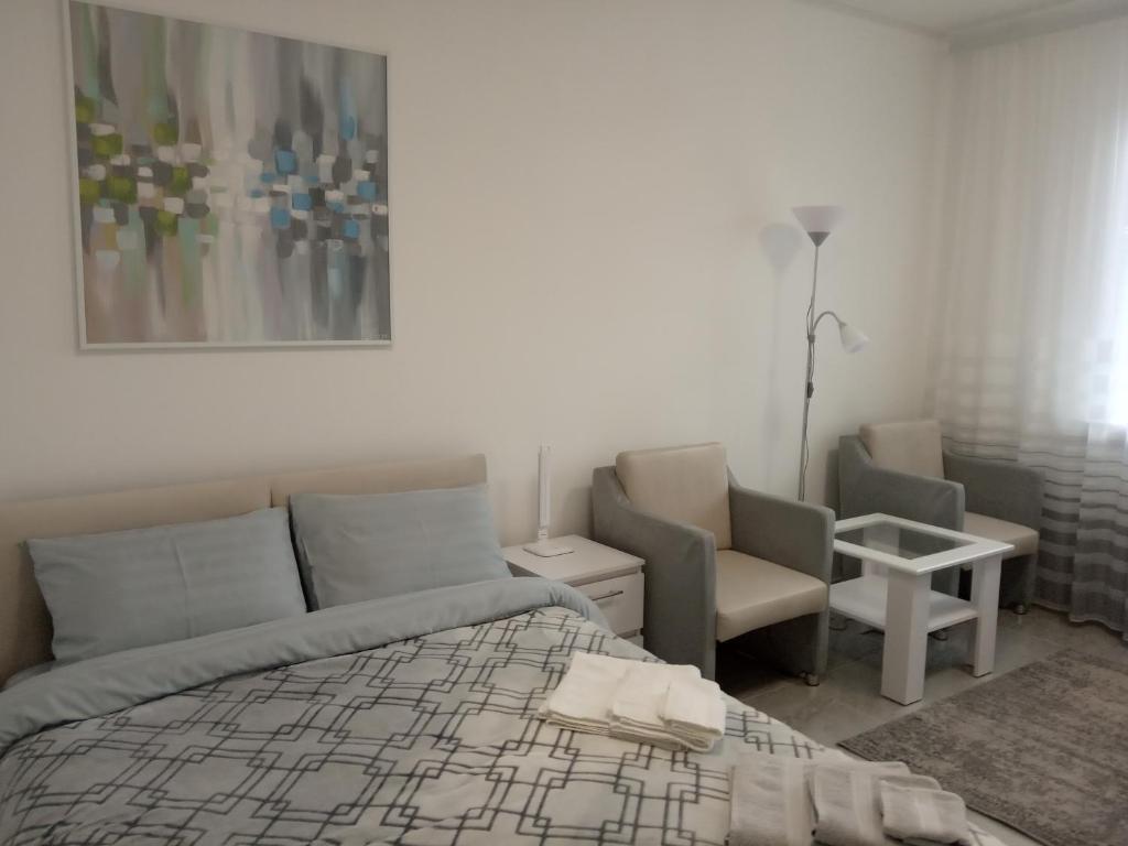 a bedroom with a bed and a couch and a chair at Modern fresh-new appartment near the park Sofievka in Umanʼ