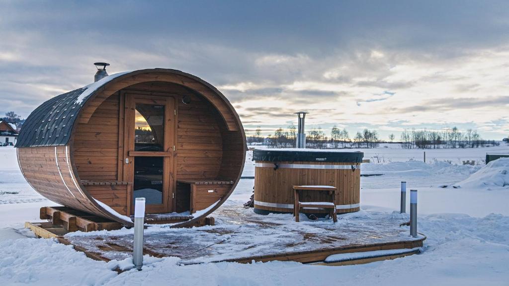 a wooden circular building in the snow with a bench at Resorts H Białka Tatrzańska z sauną, Sun & Snow in Białka Tatrzanska