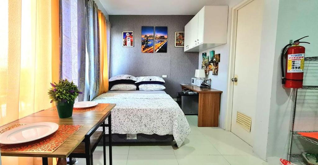 a small bedroom with a bed and a table and a sink at 913Cityscape located at city center in Bacolod
