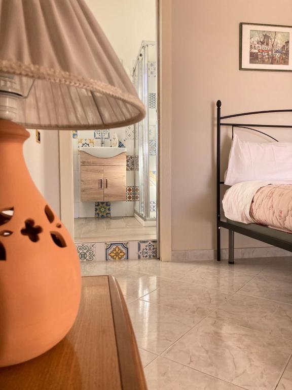 カーヴァ・デ・ティッレーニにあるMary House - Amalfi Coastのベッドルーム1室(ベッド1台、ランプ付きテーブル付)
