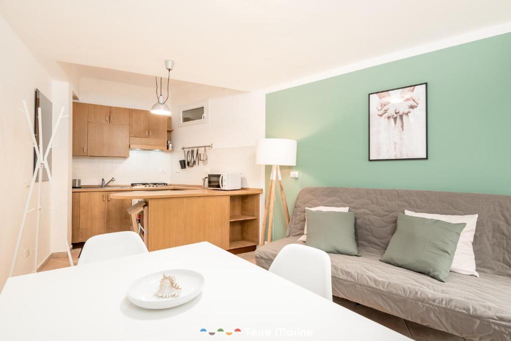 een keuken en een woonkamer met een bank en een tafel bij Rio Bello in Riomaggiore
