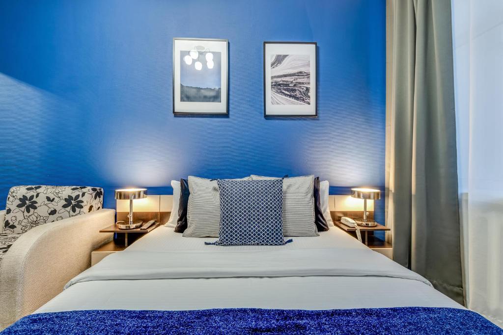 モスクワにあるDomOtel Sokolの青いベッドルーム(ベッド1台、ランプ2つ付)
