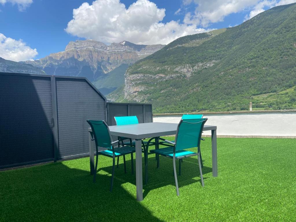 un tavolo con sedie e vista sulle montagne di Apartamento Marbore (Torla-Ordesa) a Torla