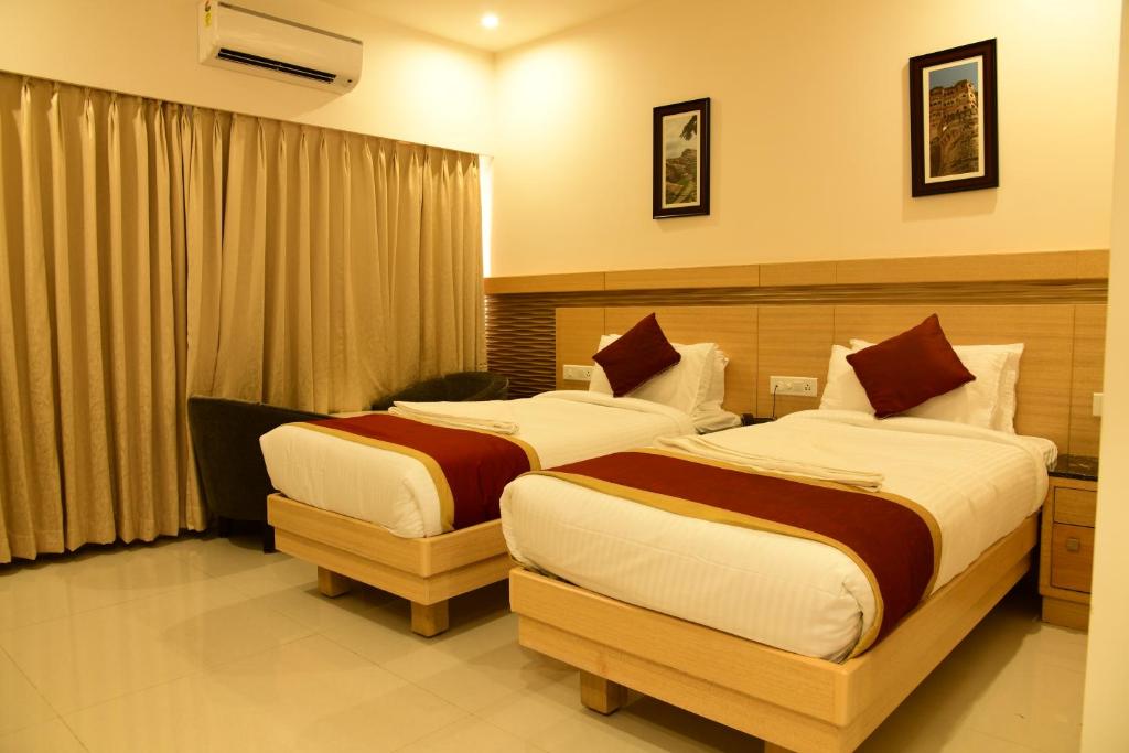 a hotel room with two beds in a room at Hotel U.T.ELITE in Bangalore