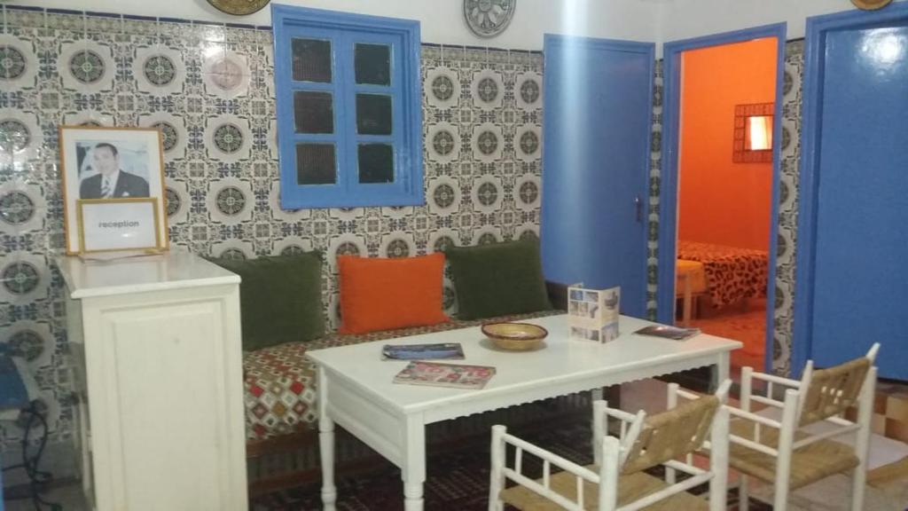 a room with a table and chairs and a couch at La maison des amis in Taroudant