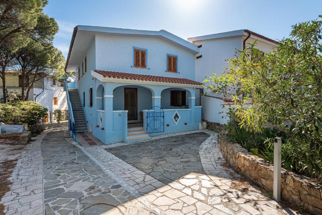 a blue and white house with a driveway at CASA AZZURRA in Cala Liberotto