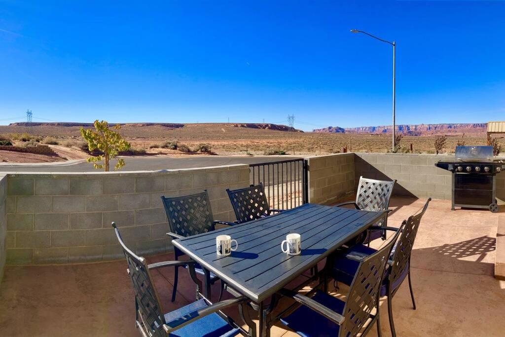 einen blauen Tisch und Stühle auf einer Terrasse mit Grill in der Unterkunft Vermillion Cliffs House in Page