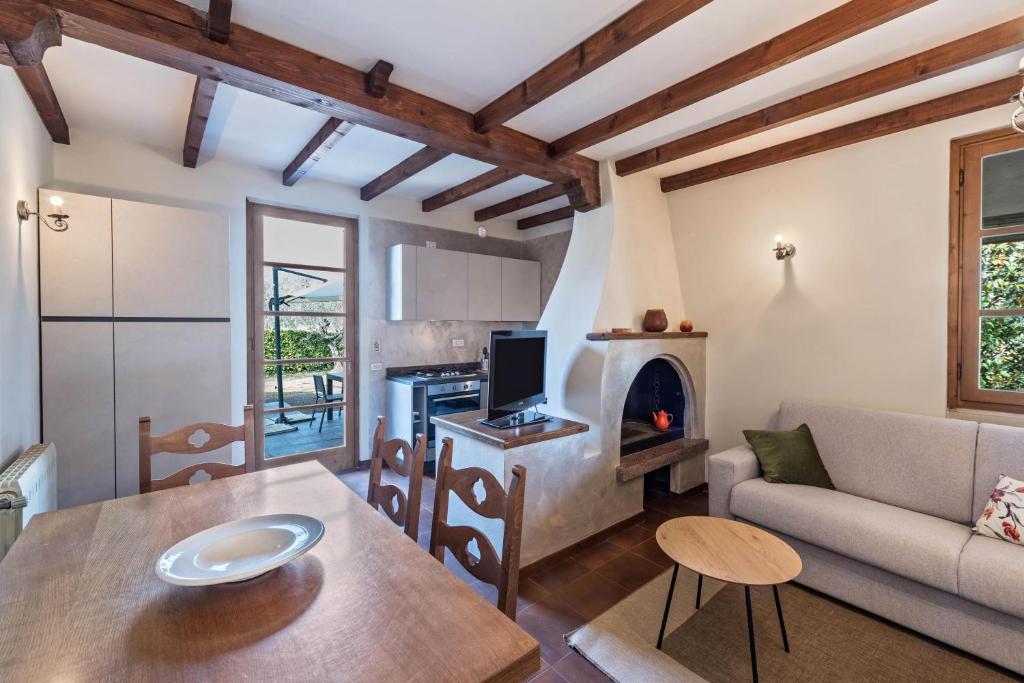 ein Wohnzimmer mit einem Tisch, einem Sofa und einem Herd in der Unterkunft Casa degli Ulivi in San Felice del Benaco