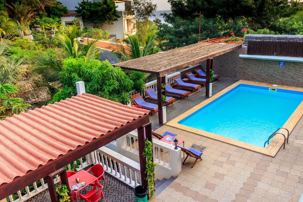 an overhead view of a swimming pool with chairs and a roof at Pousada Quinta Ribeirinha in Cidade Velha