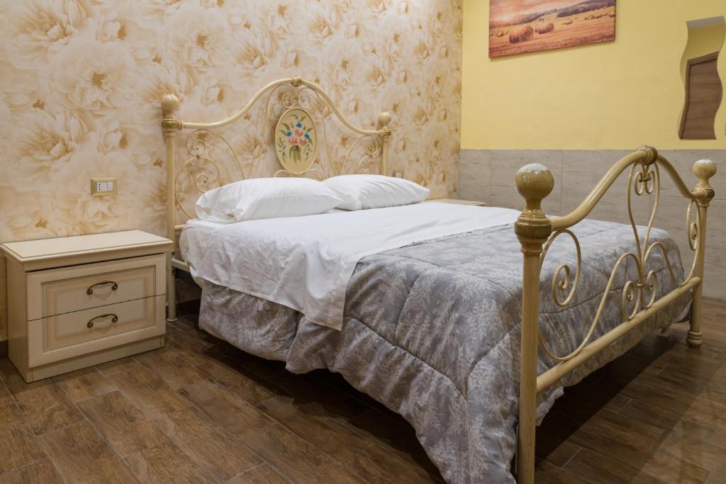 a bedroom with a bed with a white bedspread and a table at Dimora Delle Grotte in Castellana Grotte