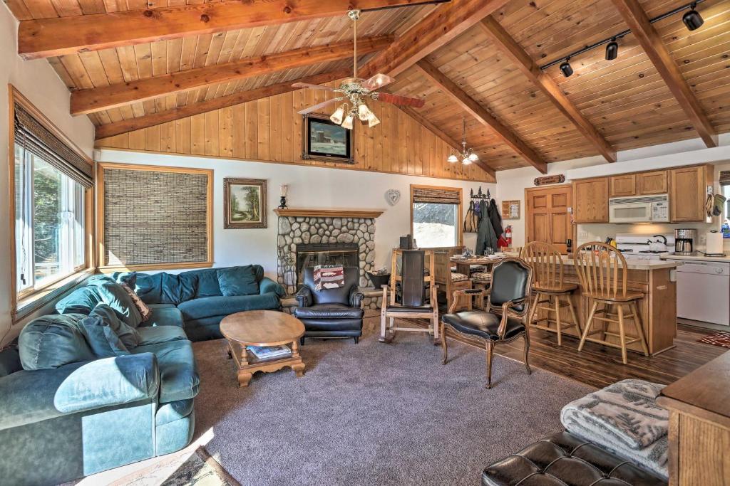 een woonkamer met een blauwe bank en een tafel bij Delightful Family Cabin Walk to Lake Gregory! in Arrowhead Highlands