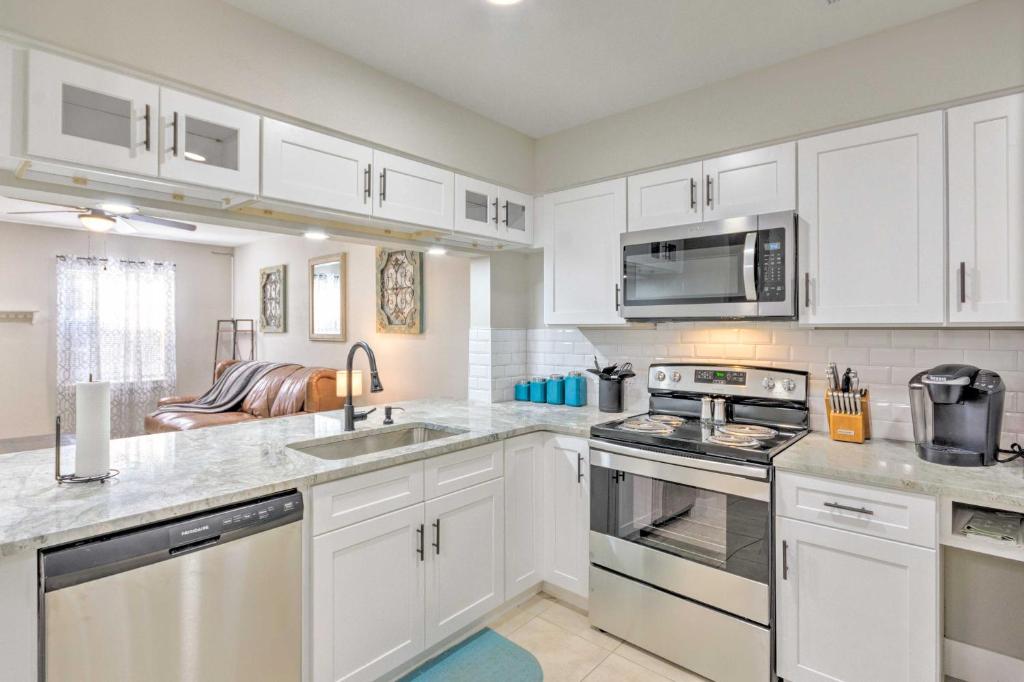 a kitchen with white cabinets and stainless steel appliances at Fort Walton Beach Townhome Less Than 3 Mi to the Beach! in Fort Walton Beach