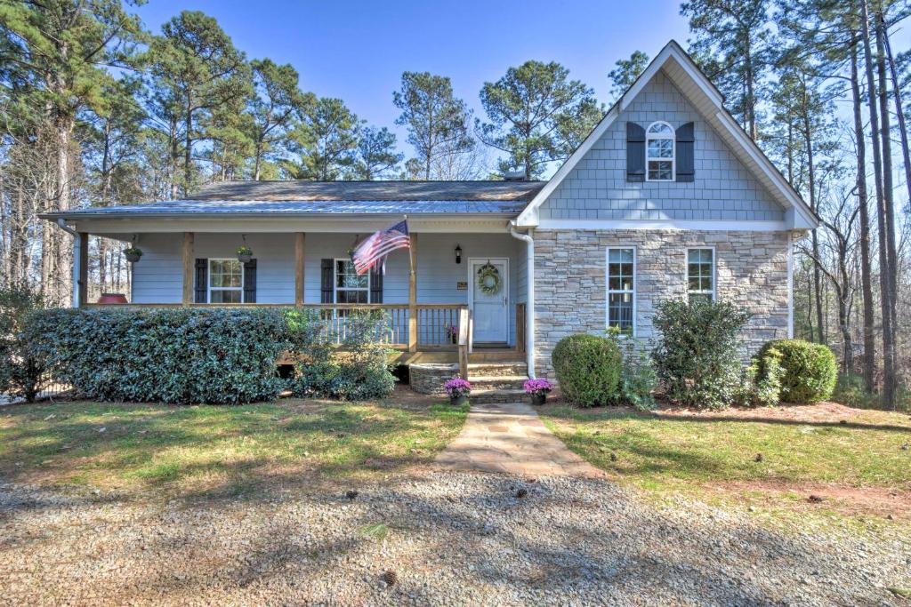 a house with an american flag in the yard at Family-Friendly Lake Lanier Escape on 2 and Acres! in Gainesville