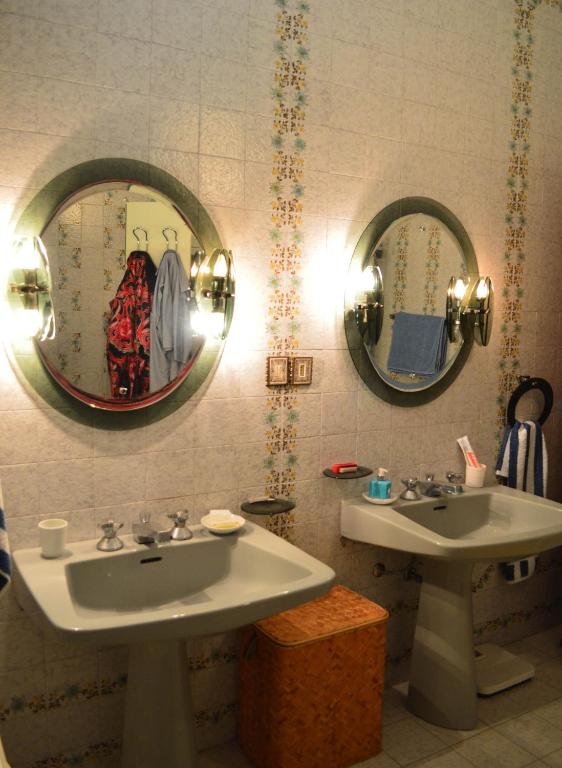 łazienka z 2 umywalkami i 2 lustrami w obiekcie Villa Luigina - seafront villa in Capo d'Orlando w mieście Capo dʼOrlando