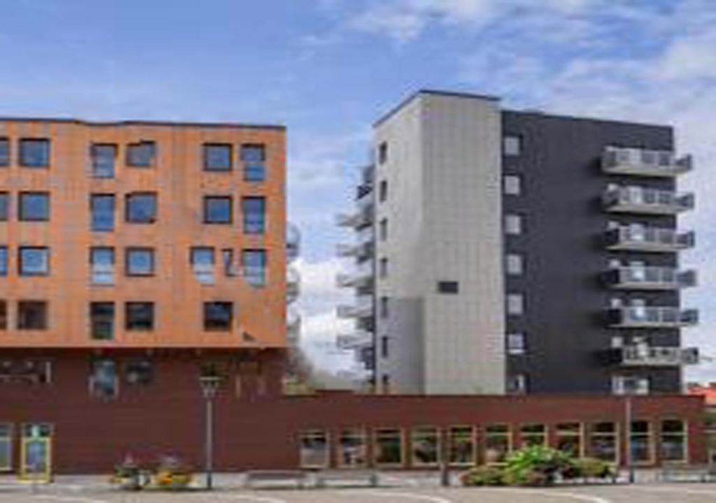 two tall buildings next to a parking lot at Continental Apartment Hotel Knivsta in Knivsta