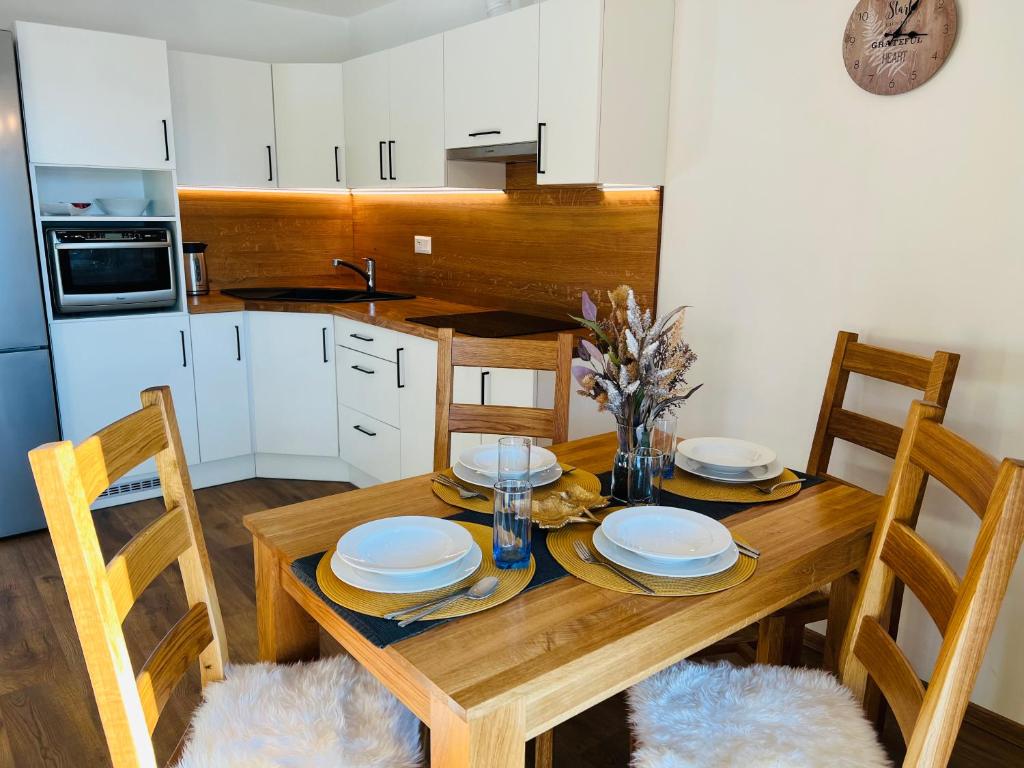 a kitchen with a wooden table with chairs and a dining room at Apartmán U Sedmikrásky in Vaclavov u Bruntalu