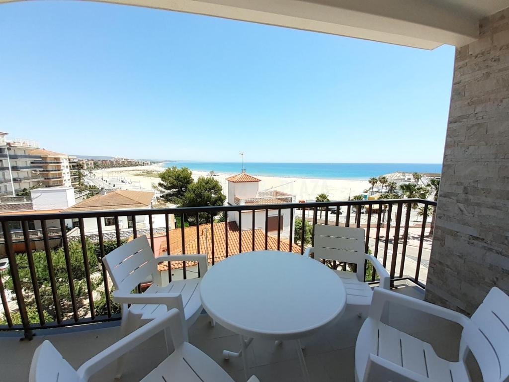 einen weißen Tisch und Stühle auf einem Balkon mit Meerblick in der Unterkunft Apartamentos Dins Mar Apto. 10 in Torredembarra