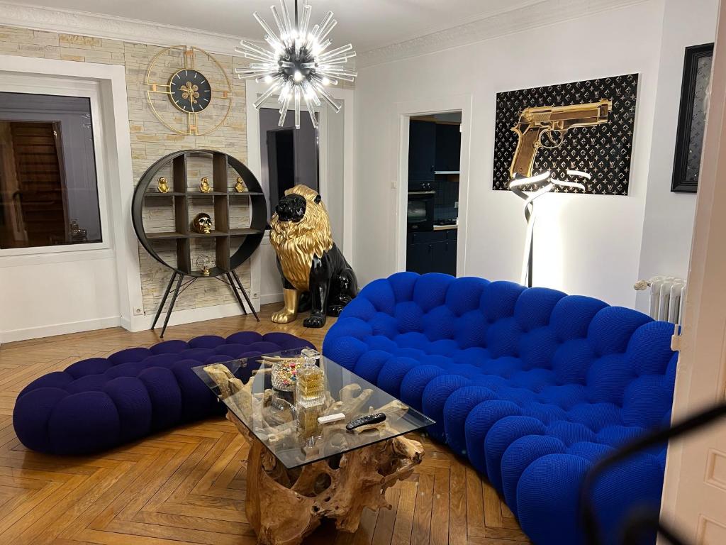 ein Wohnzimmer mit einem blauen Sofa und einem Tisch in der Unterkunft Superbe appartement avec mobilier luxueux. in Morbier