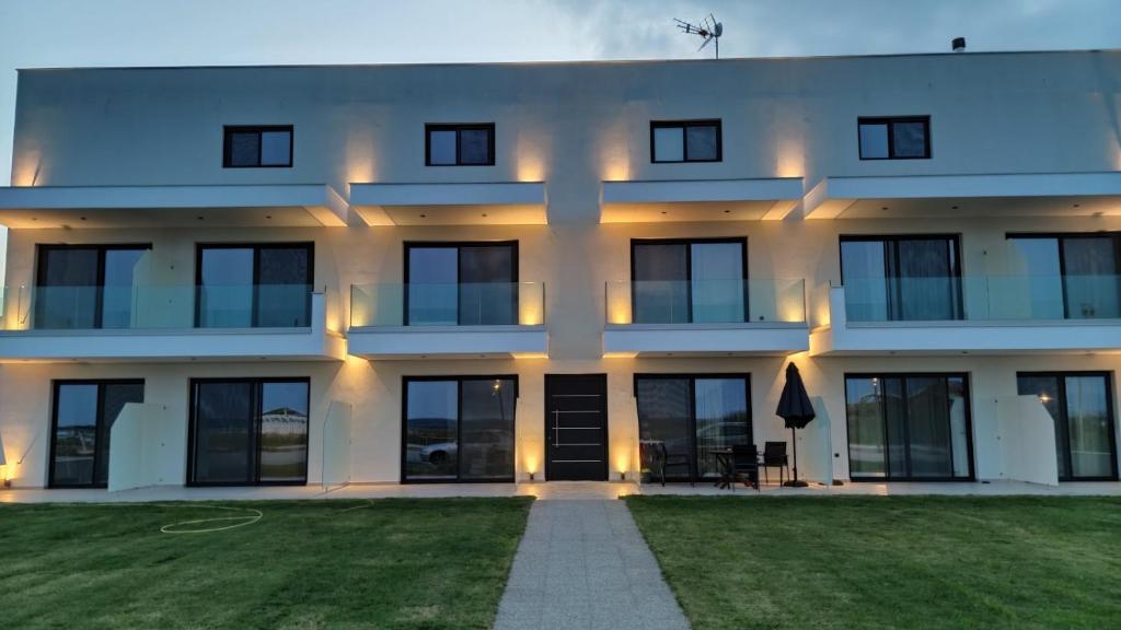a white building with a lawn in front of it at Onar Sarti Luxury Living in Sarti