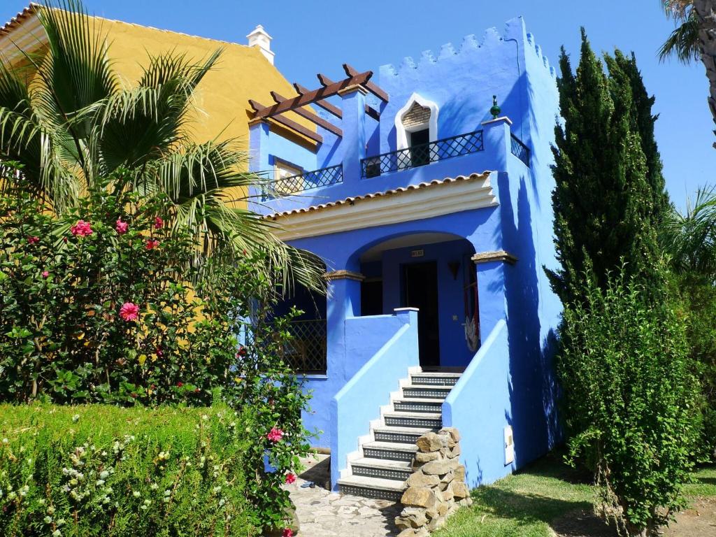 サアラ・デ・ロス・アトゥネスにあるBelvilla by OYO La Casa Az lの階段とヤシの木のある青い家