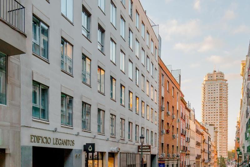 un alto edificio bianco in una strada di città con edifici di Edificio Leganitos a Madrid