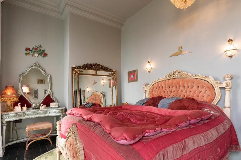 a bedroom with a large bed and a mirror at La Rosa Hotel in Whitby