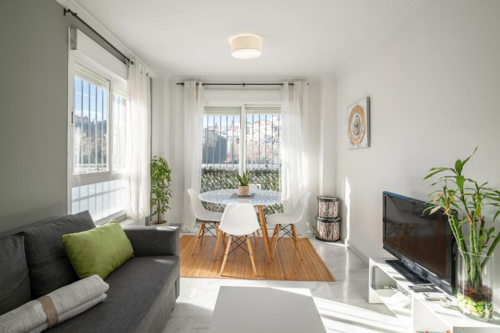 グラナダにあるEnjoyGranada TREVENQUE Centerのソファとテーブルのあるリビングルーム