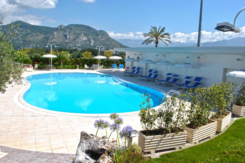 a swimming pool in a resort with mountains in the background at Edra Palace Hotel & Ristorante in Cassino