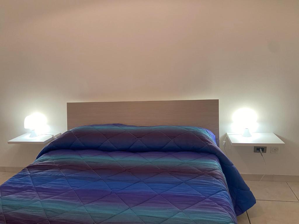 sypialnia z łóżkiem z dwoma lampkami na dwóch stołach w obiekcie Appartamento Residence Baia Blu w mieście Gallipoli
