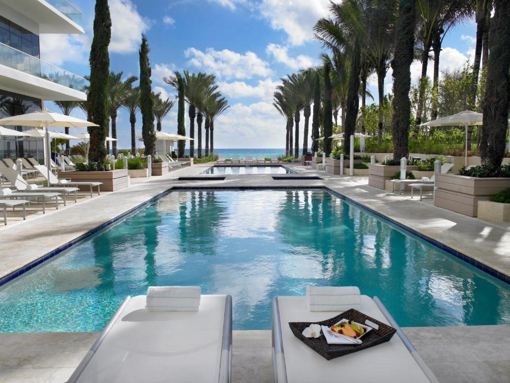 a pool at a resort with palm trees at Grand Beach Hotel Surfside in Miami Beach