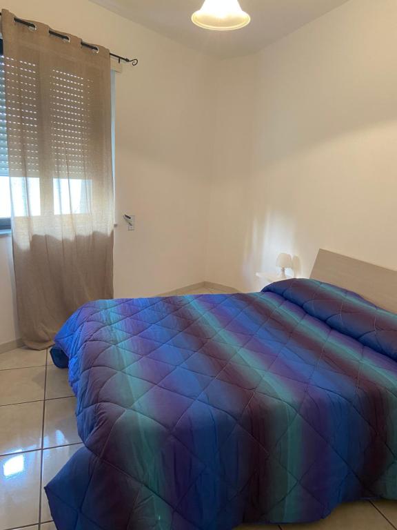 sypialnia z łóżkiem z kolorowym kocem w obiekcie Appartamento Residence Baia Blu w mieście Gallipoli